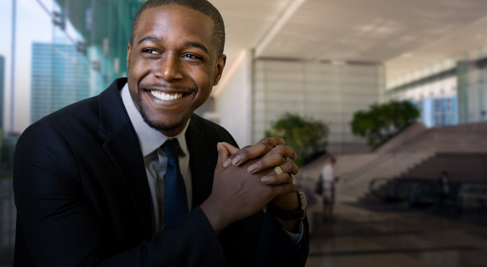 Gentleman officially dressed smiling while looking through the window in an office