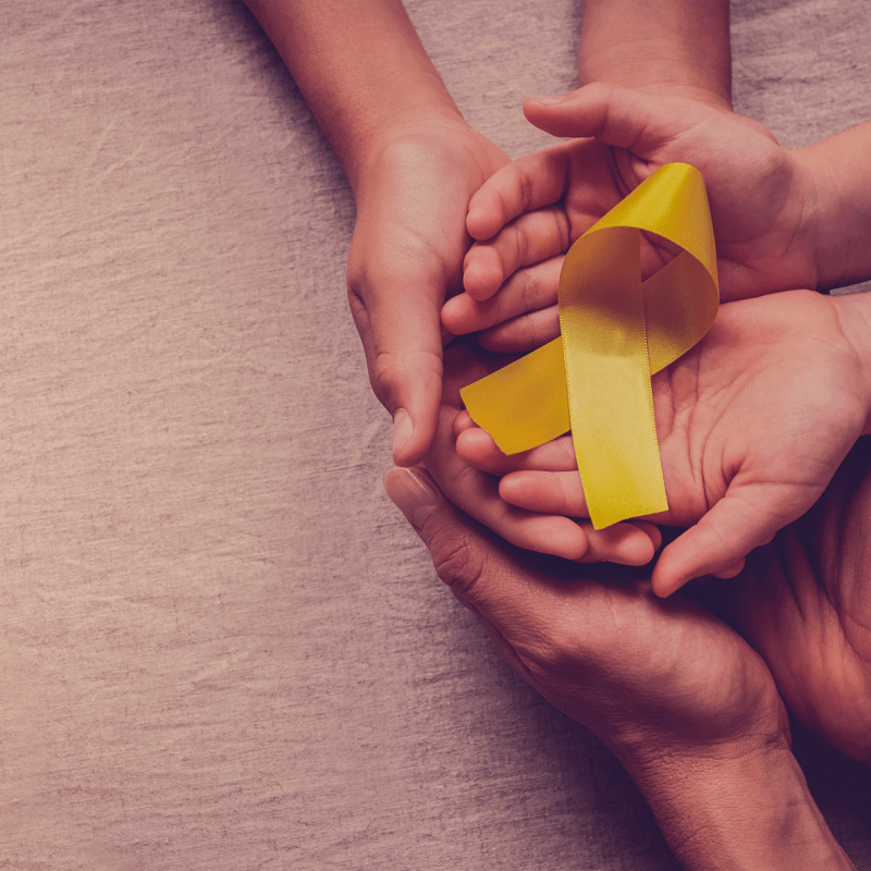 Beautiful palms holding a yellow ribbon advocating for suicide prevention