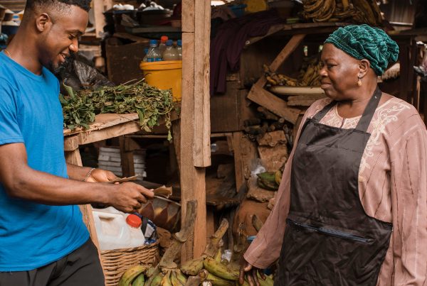 African accent Gentleman paying for vegetables in the open air market