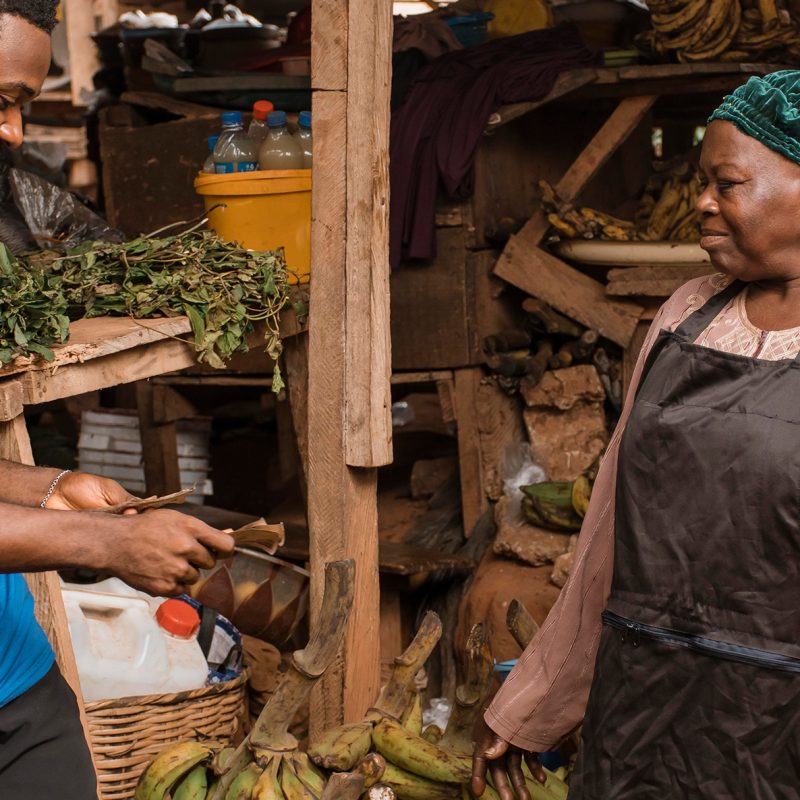 African accent Gentleman paying for vegetables in the open air market