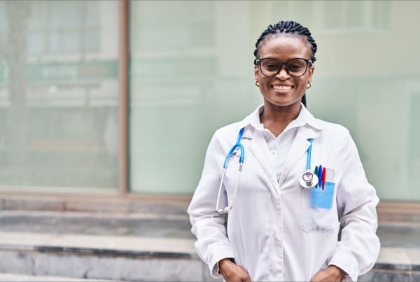 Beautiful African descent Clinical officer all smiles outdoors with stethoscope and lab coat on | Madison Professional Indemnity Cover